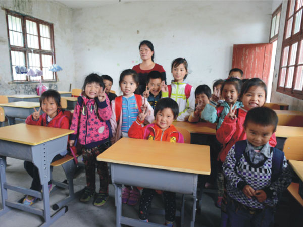 公司為一山村小學捐贈一批課桌椅，孩子們高興地和老師一起合影